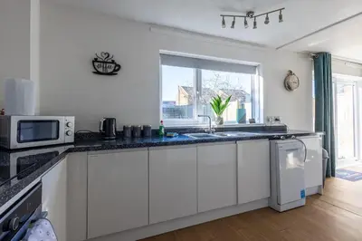 a white kitchen with a sink and a microwave at Sizewell - Lincoln - Contractor Accommodation in Saxmundham