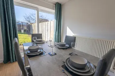 a dining room with a table and chairs and a window at Sizewell - Lincoln - Contractor Accommodation in Saxmundham