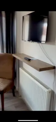 a desk with a television on a wall with a chair at Leiston house in Leiston