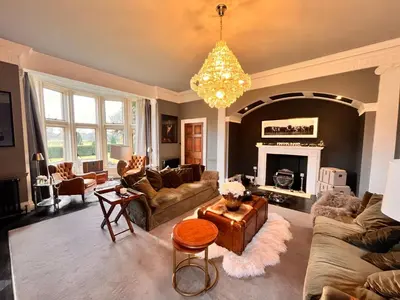 a living room with couches and a chandelier at Herringswell Manor in Red Lodge