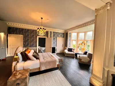 a bedroom with a bed and a living room at Herringswell Manor in Red Lodge