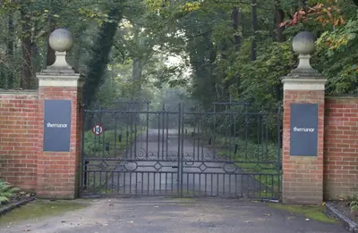 a black iron gate with a sign on it at Herringswell Manor in Red Lodge