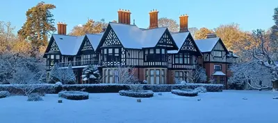a large black and white mansion in the snow at Herringswell Manor in Red Lodge