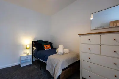 a small bedroom with a bed and a dresser at Sizewell - Contractor Accommodation in Leiston