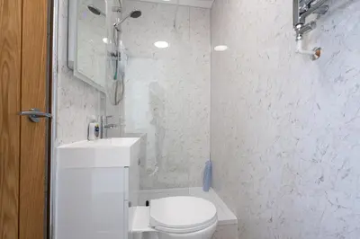 a white bathroom with a toilet and a sink at Sizewell - Contractor Accommodation in Leiston