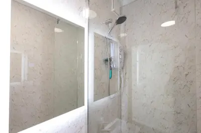 a shower in a bathroom with a glass door at Sizewell - Contractor Accommodation in Leiston
