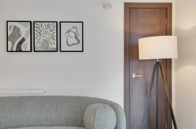 a living room with a couch and a lamp at Easy access to Central London and Stansted Airport in Harlow
