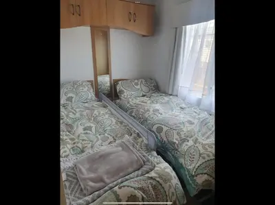 a bed in a small room with a window at Tracis home from home in Jaywick Sands