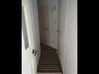 a hallway with a staircase leading to a door at Tracis home from home in Jaywick Sands