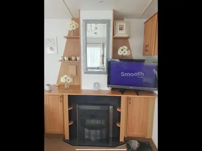 a tv sitting on top of a desk with a fireplace at Tracis home from home in Jaywick Sands