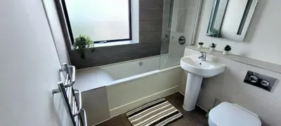 a bathroom with a sink and a toilet and a mirror at Stylish 2 Bedroom Flat near Chelmsford Station, with Free Parking, Sleeps 4 in Chelmsford
