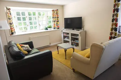 a living room with a couch and a tv at Cosy Rural Retreat Perfect for Families and Pets in Tuddenham