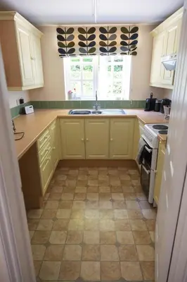 a kitchen with yellow cabinets and a sink at Cosy Rural Retreat Perfect for Families and Pets in Tuddenham