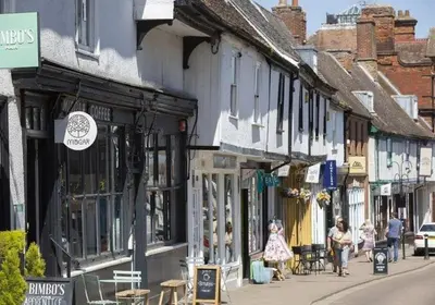 a group of people walking down a street with buildings at Cosy Rural Retreat Perfect for Families and Pets in Tuddenham