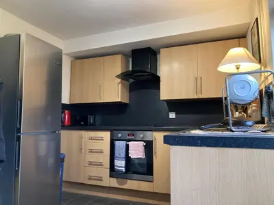 a kitchen with wooden cabinets and a blue counter top at Charming Cambridgeshire Home in Ely