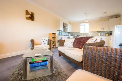 a living room with a couch and chairs and a kitchen at Comfortable 2-Bedroom Home in Framlingham in Framlingham