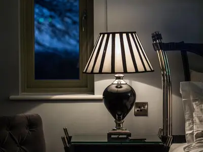 a lamp sitting on a table next to a bed at Eagle Mill Luxury Rooms in Huntingdon