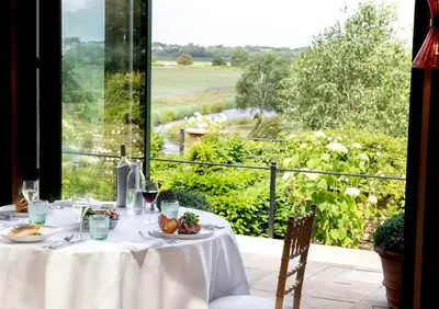 a table with plates of food and a view of a field at The Old Hall Ely in Ely
