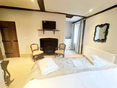 a bedroom with a bed and a tv and a fireplace at The Harvard Inn in Stock