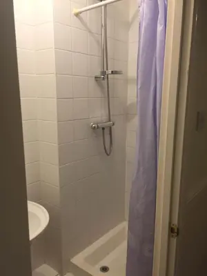 a bathroom with a shower with a toilet and a sink at Southend Inn Hotel - Close to Beach, Train Station & Southend Airport in Southend-on-Sea