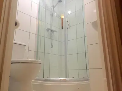 a bathroom with a shower and a toilet at Southend Inn Hotel - Close to Beach, Train Station & Southend Airport in Southend-on-Sea