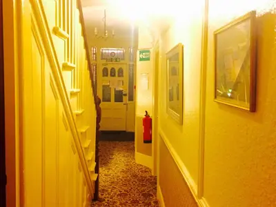 a hallway with yellow walls and a yellow door at Southend Inn Hotel - Close to Beach, Train Station & Southend Airport in Southend-on-Sea