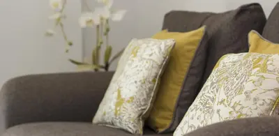 a gray couch with yellow and white pillows on it at Citystay Living - Vesta Apartments in Cambridge
