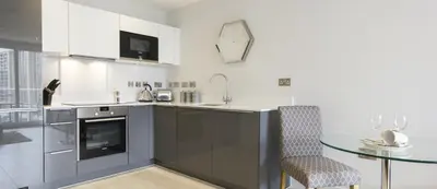 a kitchen with a glass table and a glass table and a table and a counter at Citystay Living - Vesta Apartments in Cambridge