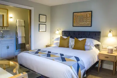 a bedroom with a large bed and a bathroom at Crown & Punchbowl in Cambridge