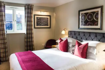 a bedroom with a large white bed with red pillows at Crown & Punchbowl in Cambridge