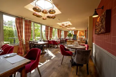 a restaurant with tables and chairs and windows at Crown & Punchbowl in Cambridge