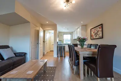 a dining room and living room with a table and chairs at Camstay New Street in Cambridge