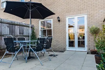 a table and chairs with an umbrella on a patio at Camstay New Street in Cambridge