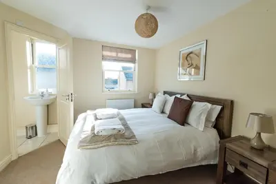 a bedroom with a large white bed and a sink at Camstay New Street in Cambridge