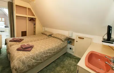a small bedroom with a bed and a sink at Isleham River Lodge in Isleham