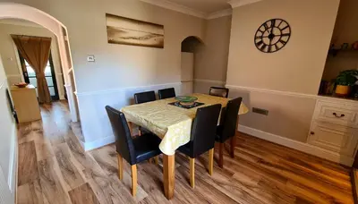 a dining room with a table and chairs at Castle Cottage in Rayleigh