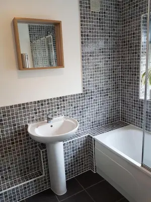 a bathroom with a sink and a tub and a mirror at Castle Cottage in Rayleigh