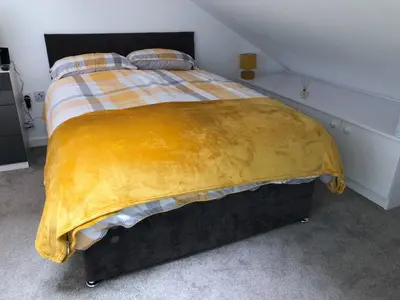 a bed with a yellow blanket on top of it at Toothbrush Apartments - Ipswich Central East in Ipswich