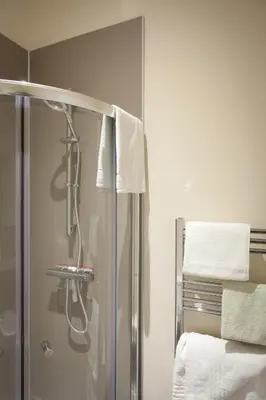 a shower in a bathroom with towels on the wall at Toothbrush Apartments - Ipswich Central East in Ipswich
