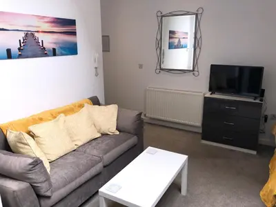 a living room with a couch and a flat screen tv at Toothbrush Apartments - Ipswich Central East in Ipswich