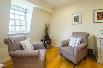 a living room with two chairs and a window at Seascape in Aldeburgh