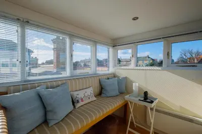 a bench in a room with windows and a view of the city at Seascape in Aldeburgh