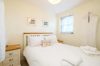 a bedroom with a white bed and a window at Seascape in Aldeburgh