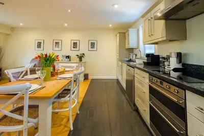 a kitchen with a table and a dining room at Seascape in Aldeburgh