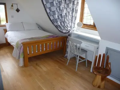 a bedroom with a bed and a desk and a chair at Oakwrights in Terling