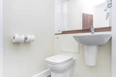 a white bathroom with a toilet and a sink at Mermaid, Ipswich by Marston's Inns in Ipswich