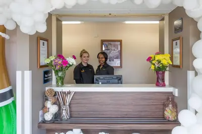 two women standing at a reception desk in a mirror at Mermaid, Ipswich by Marston's Inns in Ipswich