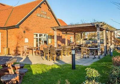 a patio with tables and chairs in front of a building at Mermaid, Ipswich by Marston's Inns in Ipswich