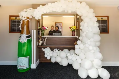 a balloon arch with white balloons and a bottle of champagne at Mermaid, Ipswich by Marston's Inns in Ipswich