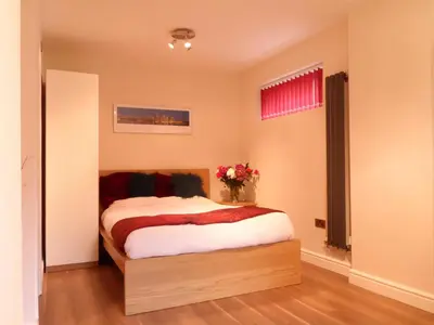 a bedroom with a bed and a vase of flowers at Old School House Studio in Stetchworth